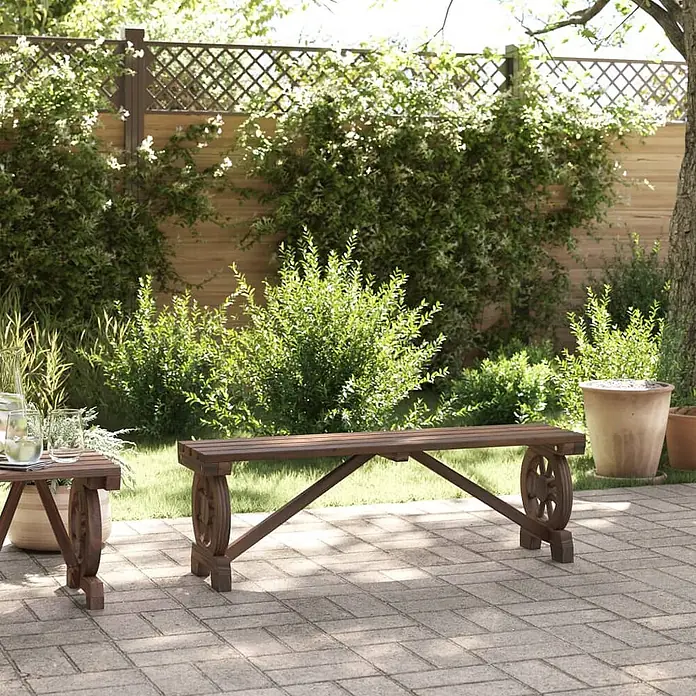 Furnicato Gartenbank Tannen-Massivholz gebrannt - B x T x H: 115 x 28 x 39,5 cm, Dunkelbraun - Dunkelbraune Holzbank und passender Beistelltisch mit Wagenrad-Beinen auf einer gepflasterten Terrasse im Garten.