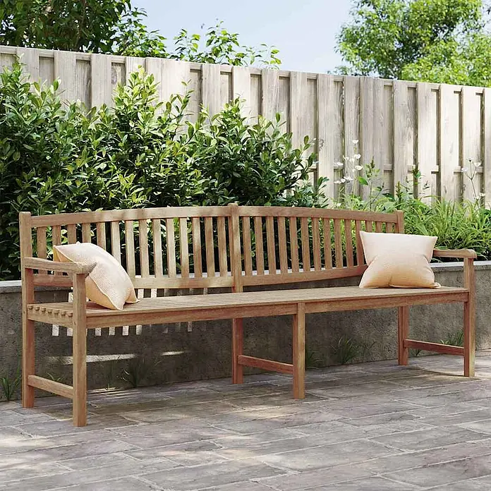 Furnicato Gartenbank - Braun - Lange, hellbraune Holzgartenbank mit zwei hellen Kissen in einer Gartenumgebung.