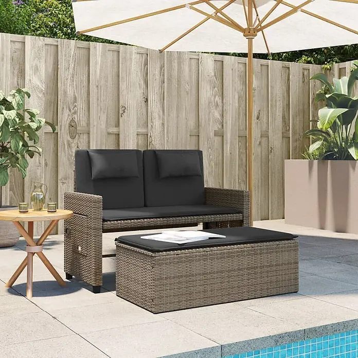 Furnicato Gartenbank PE-Rattan - B x T x H: 122 x 102 x 60 cm, Grau - Braunes Rattan-Gartensofa mit dunkelgrauen Kissen und passendem Stauraum-Ottomane auf einer Terrasse. Inklusive Beistelltisch.