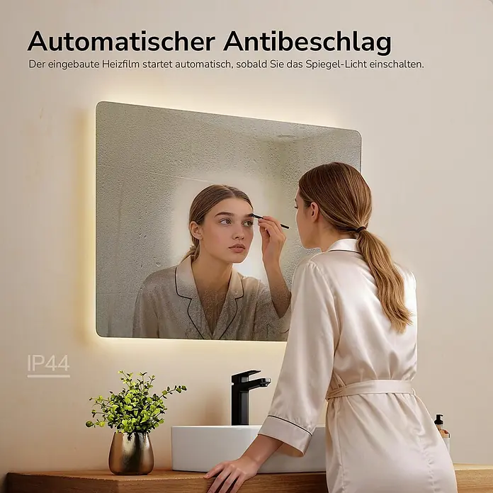 Emke Lichtspiegel Glowrim LM09 -  - Beleuchteter Badspiegel mit automatischer Antibeschlagfunktion, IP44-zertifiziert. Eine Frau schminkt sich im klaren Spiegelbild.