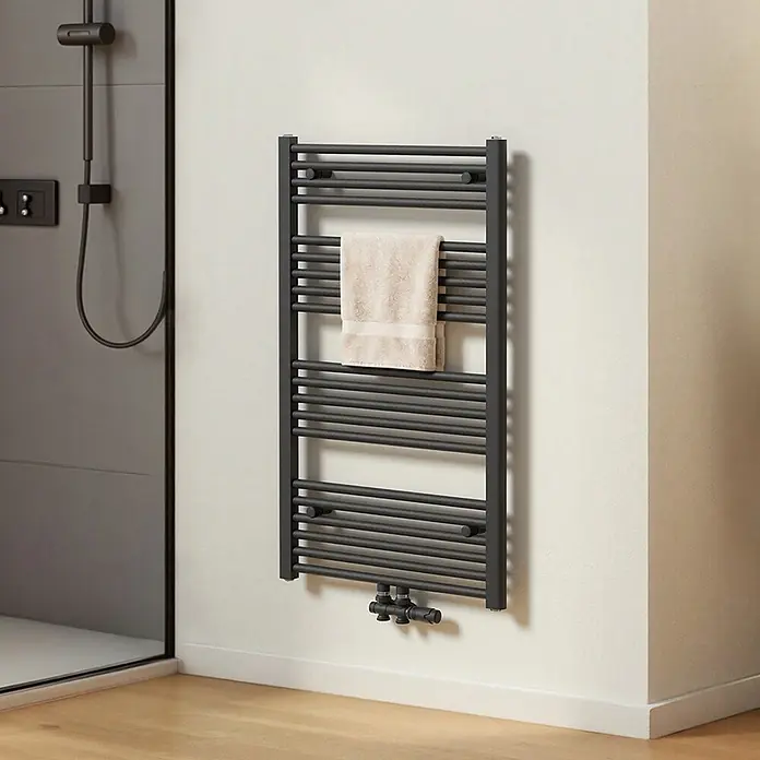 Emke Badheizkörper Orbrad TR - B x H: 60 x 100 cm, Anthrazit - Anthrazitfarbener Handtuchwärmer mit beigem Handtuch in einem modernen Badezimmer neben einer Dusche.