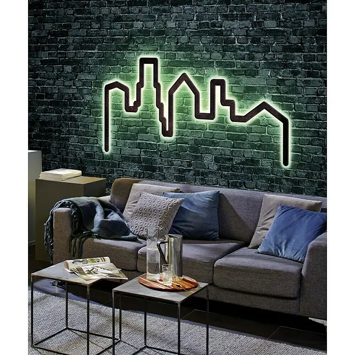 Paulmann LED-Band FlexLED 3D Basisset RGB - Länge: 1,5 m, Lichtfarbe: RGB, 11 W - Eine Skyline-Wandleuchte mit grüner LED-Beleuchtung, die eine moderne Atmosphäre in einem Wohnzimmer mit grauer Couch und Backsteinmauer schafft.