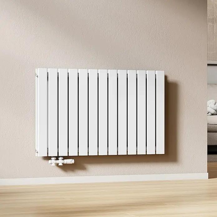 Emke Designheizkörper Flatrad FR - Wärmeleistung bei Vorlauftemperatur von 75 °C (D: 50): 1.343 W, Weiß - Weißer, moderner Vertikalplattenheizkörper an heller Wand über Holzboden mit sichtbaren Rohrverbindungen.
