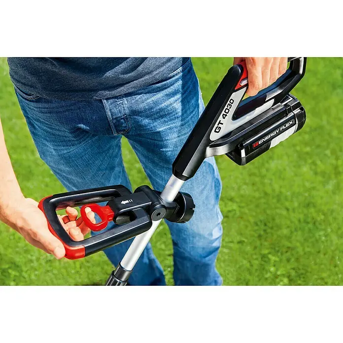 AL-KO 36V Akku-Rasentrimmer GT 4030 - 36 V, 4 Ah, Li-Ionen, Ohne Akku, Schnittbreite Faden: 30 cm - Eine Nahaufnahme eines Benutzers, der einen GT 4030 Rasentrimmer mit ENERGY FLEX Akku auf grünem Gras hält.