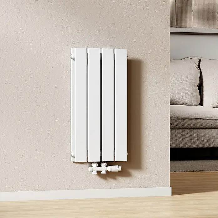 Emke Designheizkörper Flatrad FR - Wärmeleistung bei Vorlauftemperatur von 75 °C (D: 50): 327 W, Weiß - Weißer vertikaler Heizkörper an einer strukturierten Wand installiert, mit Rohrverbindungen unten, neben einem Sofa.