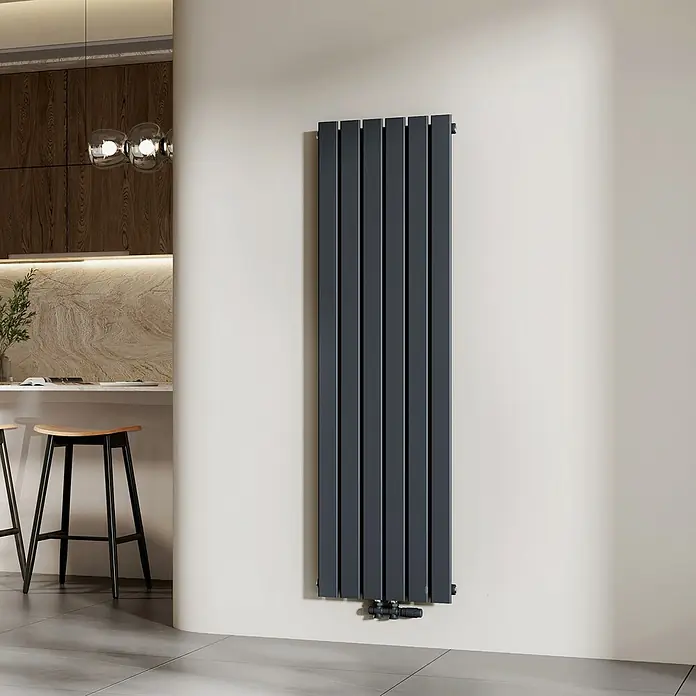 Emke Designheizkörper Flatrad FR - Wärmeleistung bei Vorlauftemperatur von 75 °C (D: 50): 850 W, Anthrazit - Langer, dunkelgrauer Vertikalheizkörper an einer Wand in einem modernen Interieur.