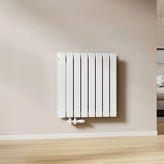 Emke Designheizkörper Flatrad FR - Wärmeleistung bei Vorlauftemperatur von 75 °C (D: 50): 826 W, Weiß - Weißer Flachheizkörper an beiger Wand über Holzfußboden, mit sichtbaren Rohrverbindungen.