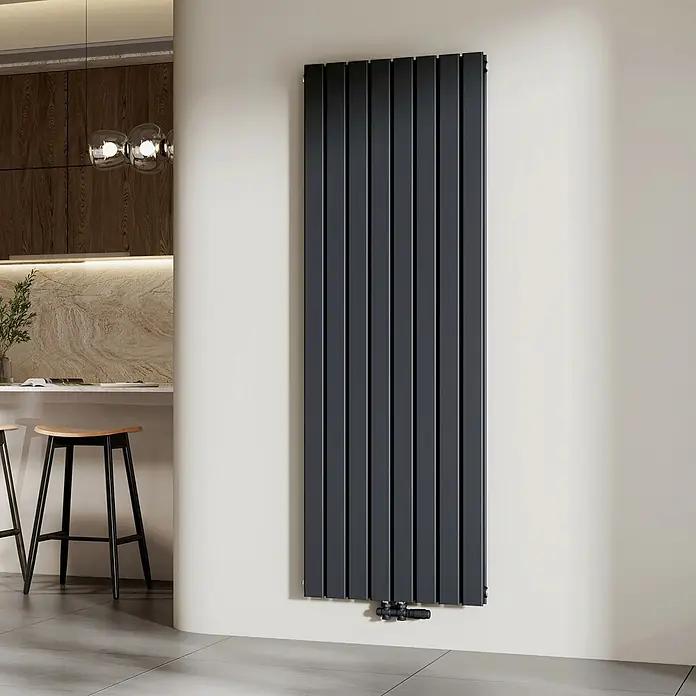 Emke Designheizkörper Flatrad FR - B x H: 62 x 180 cm, Wärmeleistung bei Vorlauftemperatur von 75 °C (D: 50): 2.227 W, Anthrazit - Vertikaler anthrazitfarbener Heizkörper mit flachen Paneelen an einer hellen Wand neben einer modernen Kücheninsel.
