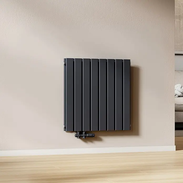 Emke Designheizkörper Flatrad FR - Wärmeleistung bei Vorlauftemperatur von 75 °C (D: 50): 826 W, Anthrazit - Moderner, anthrazitgrauer Vertikalheizkörper mit flachen Platten, an heller Wand montiert, mit sichtbaren Anschlussventilen.