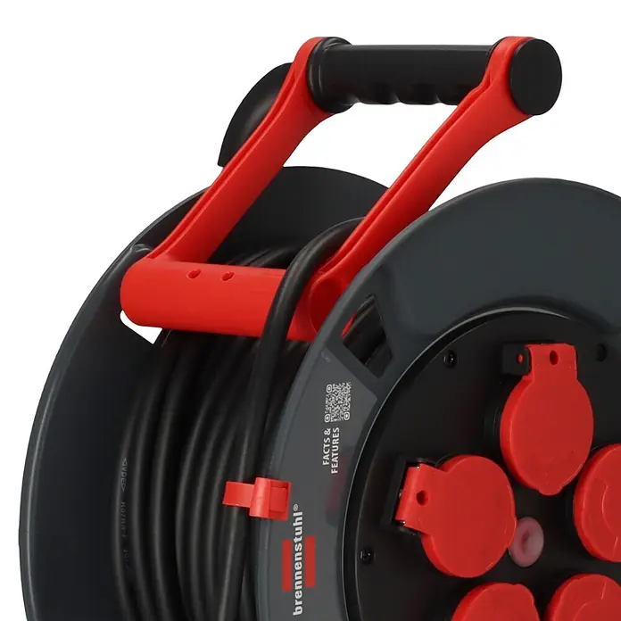 Brennenstuhl Kabeltrommel 300 KU 2100 - Kunststoff, 25 m, H07RN-F, IP44 - Schwarze Kabeltrommel mit rotem Griff und mehreren abgedeckten roten Steckdosen. Robuste Ausführung zur Stromverteilung.