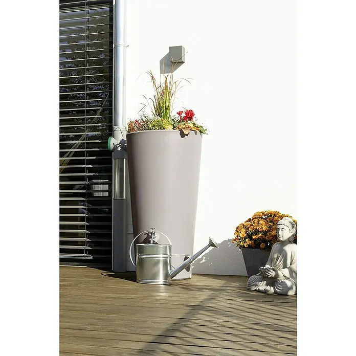 Arves Regenspeicher Rainbowl Flower - 150 l, Taupe - Wasserspeicher mit Pflanzeinsatz und Gießkanne auf einer Terrasse neben einer Buddha Statue.