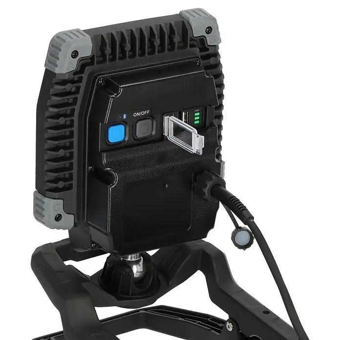 Brennenstuhl LED-Baustrahler - 6.800 lm, 6.500 K, 18 x 11 x 28,6 cm, IP65 - Schwarzer LED-Arbeitsscheinwerfer mit grauen Akzenten, zeigt Bedientasten, USB-Anschlüsse, Akkuanzeige und Netzkabel am schwarzen Ständer.