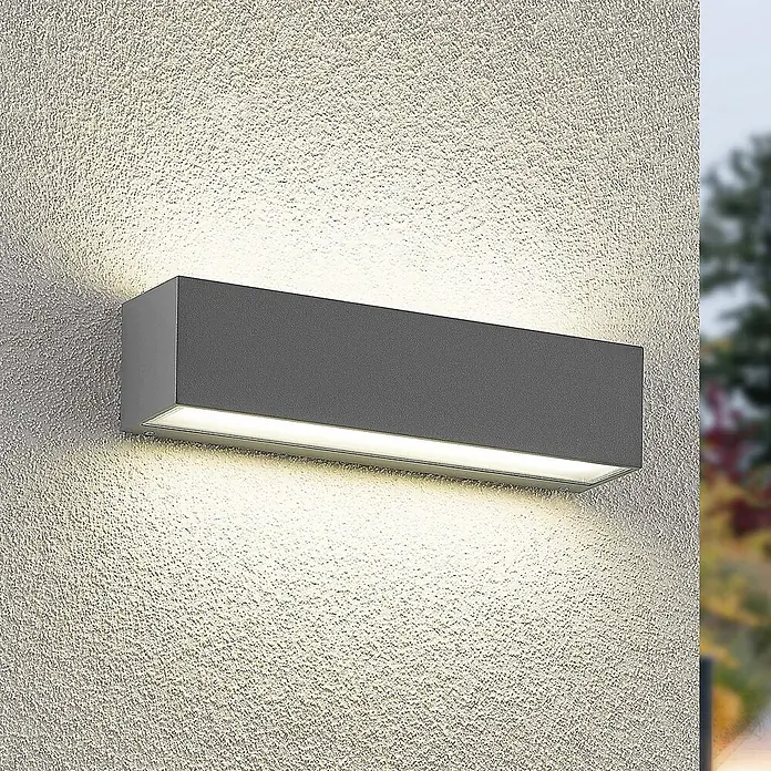 Arcchio Außenwandleuchte Lengo - alu / grau / zink, IP65 - Dunkelgraue rechteckige Außenwandleuchte, die eine strukturierte Fassade nach oben und unten beleuchtet.