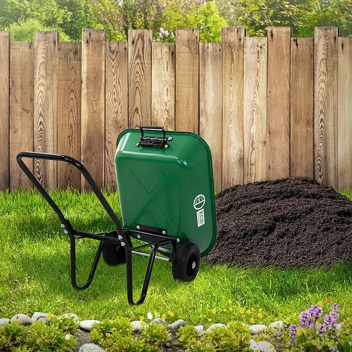 ECD Germany Gartenschubkarre Garden 78L Gartenwagen Gartenkarre mit Kippfunktion Bauschubkarre - 78 l, Material Wanne: Kunststoff - Grüne Schubkarre mit schwarzem Gestell und Rädern in einer Gartenumgebung neben einem Haufen dunkler Erde.