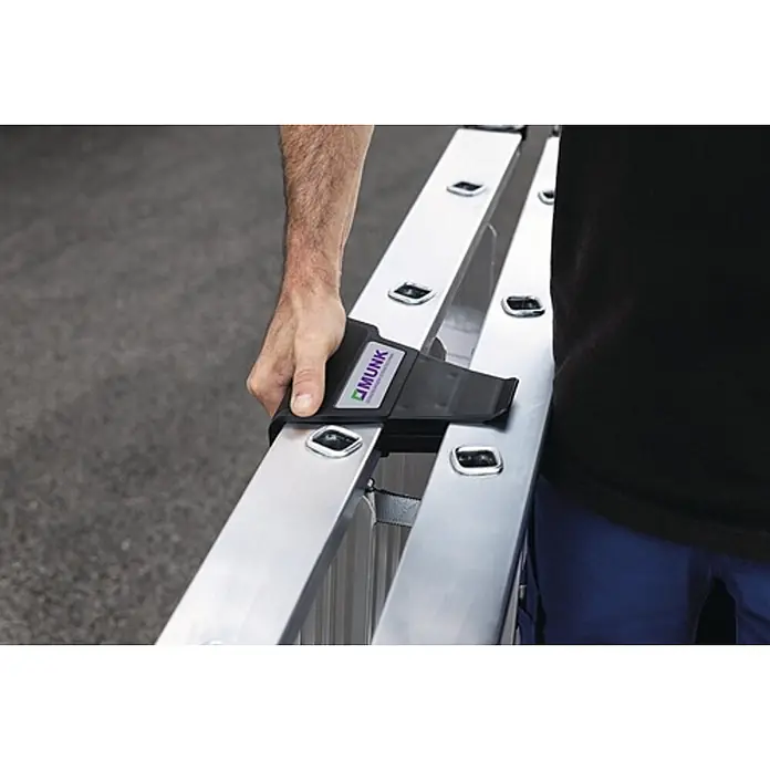 Munk Stehleiter Stehleiter mit ergo-pad beidseitig begehbar 2x3 Stufen - Anzahl Tritte: 3 Stk., Arbeitshöhe: 0,67 m, Belastbarkeit: 150 kg, Aluminium - Person trägt Aluminiumleiter mit schwarzem ergonomischem MUNK Tragegriff.