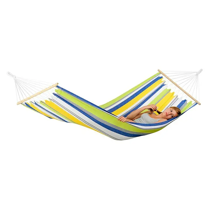 Amazonas Stabhängematte Tonga Kolibri - L x B: 310 x 100 cm, Grün/Weiß/Gelb/Blau - Frau entspannt in einer gestreiften Hängematte mit Holzspreizstäben, die zum Entspannen im Freien einlädt.