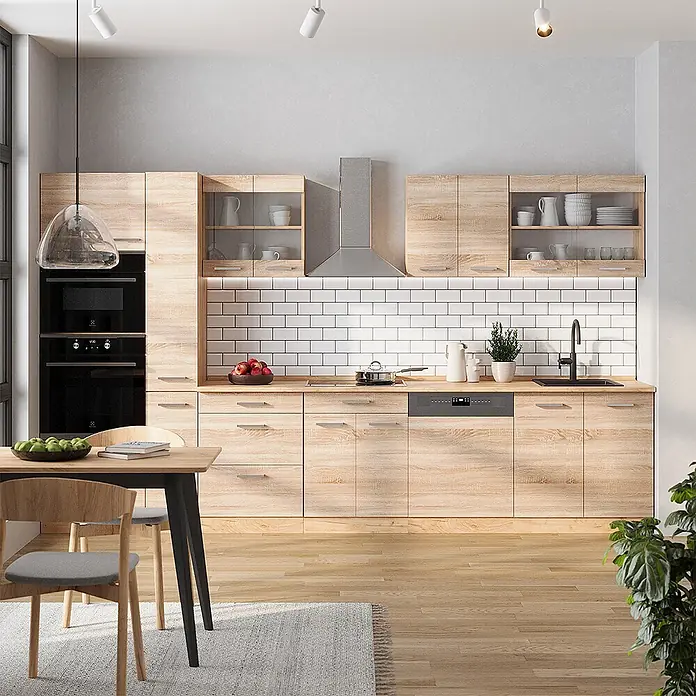 Vicco Küchenzeile R-Line Sonoma/Goldkraft Eiche ohne Arbeitsplatte - Sonoma, Ohne Elektrogeräte - Moderne Küche mit hellen Holzfronten, weißem Fliesenspiegel, schwarzen Geräten und Essbereich.