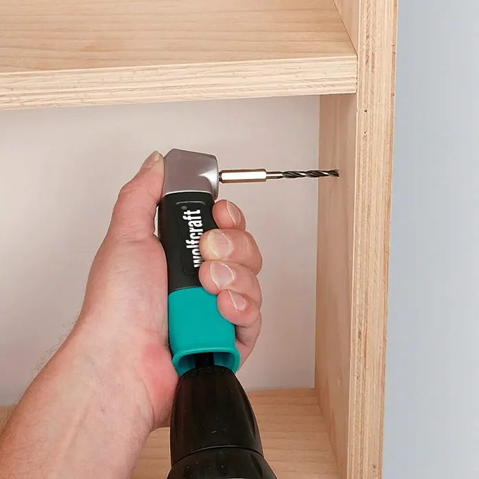 Wolfcraft Winkelgetriebe - Durchmesser Schaft: ¼″ Hex, Max. Drehzahl: 400 U/min - Nahaufnahme eines Wolfcraft Winkelkopf-Aufsatzes für Bohrmaschine beim Bohren in Holz.
