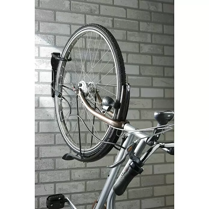 Mottez Gancho de pared para bicicletas B865V - Acero, Negro - Bicicleta plateada y marrón guardada verticalmente en un soporte de pared negro.