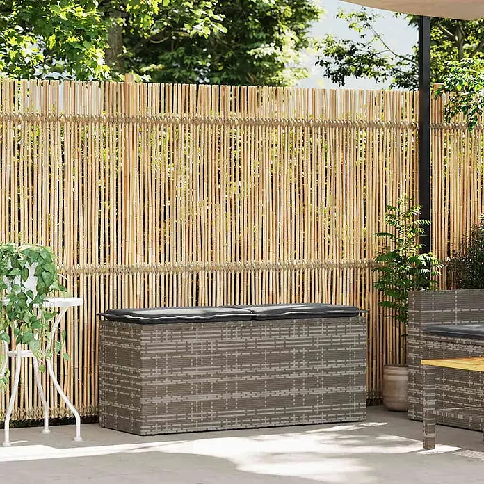 Furnicato Gartenbank PE-Rattan - B x T x H: 110 x 40 x 44 cm, Grau - Hellbrauner natürlicher Bambus-Sichtschutz als Zaun in einem Garten mit Gartenmöbeln.