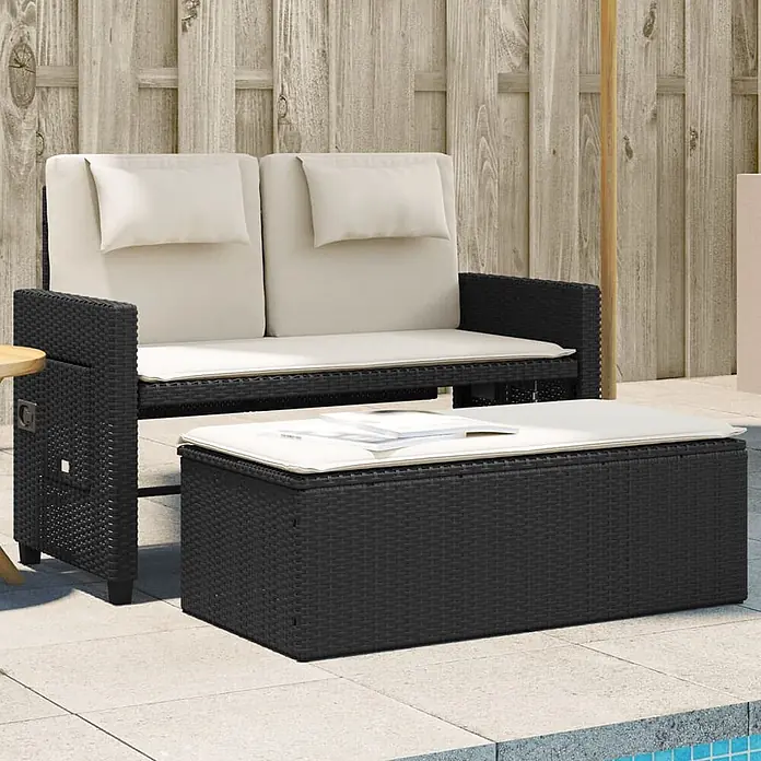 Furnicato Gartenbank PE-Rattan - B x T x H: 122 x 102 x 60 cm, Schwarz und Creme - Schwarzes Rattan-Gartensofa mit beigen Kissen und passendem Stauraumtisch auf einer Terrasse.