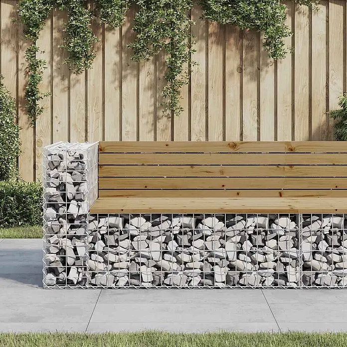 Furnicato Gartenbank - Dunkelbraun - Gartenbank aus Gabionen mit hellgrauen Steinen und naturbelassenen Holzlatten vor einem Holzzaun mit Kletterpflanzen.