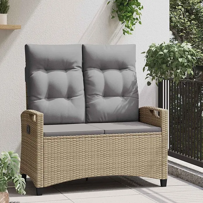 Furnicato Gartenbank pulverbeschichtet - B x T x H: 60 x 105 x 112 cm, Beige und Hellgrau - Beigefarbene Rattan-Zweisitzer-Bank für den Außenbereich mit grauen Kissen auf einem Balkon, umgeben von Grünpflanzen.