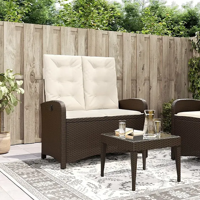 Furnicato Gartenbank - B x T x H: 59 x 86 x 93 cm, Braun und Creme - Braune Rattan-Gartenbank mit Stauraum und cremefarbenen Kissen auf einer Terrasse.