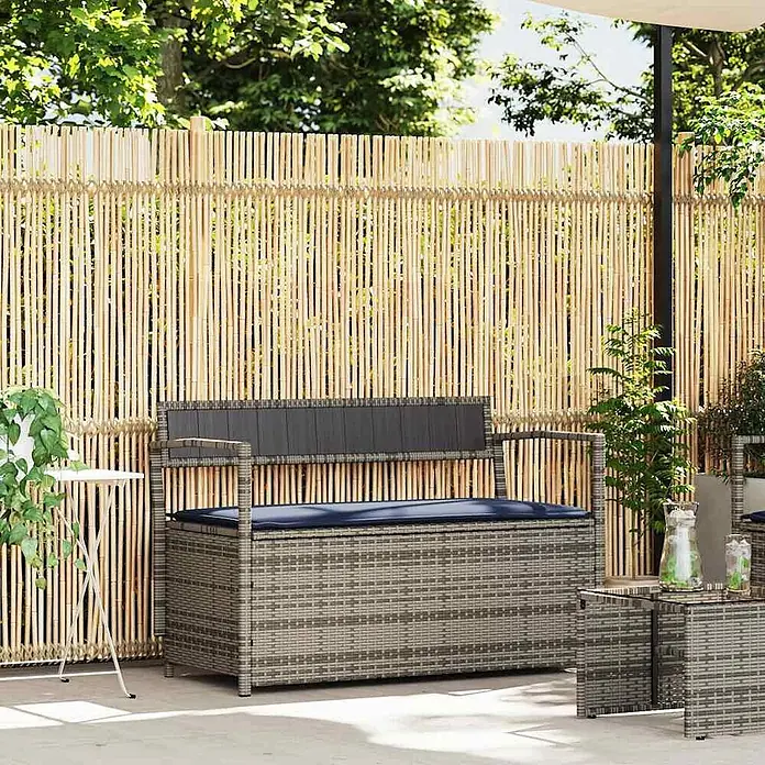 Furnicato Gartenbank PE-Rattan - B x T x H: 111,5 x 54 x 74 cm, Grau und Marineblau - Graue Outdoor-Truhenbank in Rattanoptik mit dunkler Rückenlehne und blauem Kissen.