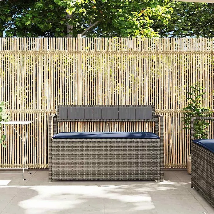 Furnicato Gartenbank PE-Rattan - B x T x H: 111,5 x 54 x 74 cm, Grau und Marineblau - Graue Rattan-Outdoor-Sitzbank mit dunkelblauem Kissen und dunkelgrauer Rückenlehne auf einer Terrasse.