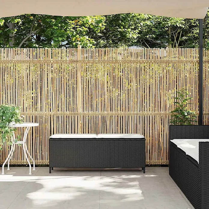 Furnicato Gartenbank PE-Rattan - B x T x H: 110 x 30 x 40,5 cm, Schwarz und Creme - Natürlicher Bambus-Sichtschutz für den Außenbereich, auf einer Terrasse mit dunklen Gartenmöbeln.