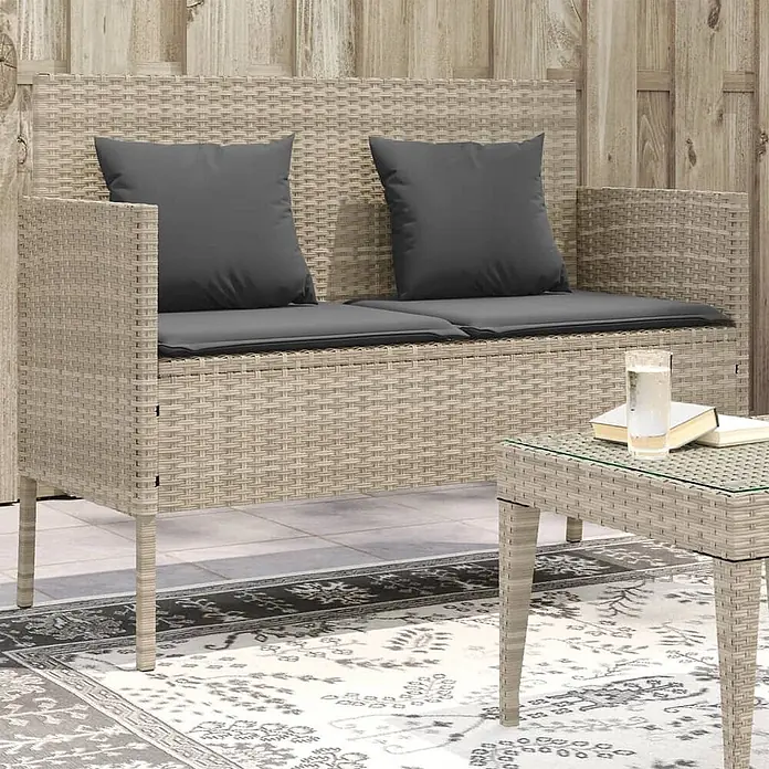 Furnicato Gartenbank PE-Rattan - B x T x H: 113 x 61 x 87 cm, Hellgrau - Beigefarbenes Rattan-Gartensofa für zwei Personen mit dunklen Kissen und passendem Beistelltisch auf einer Terrasse.