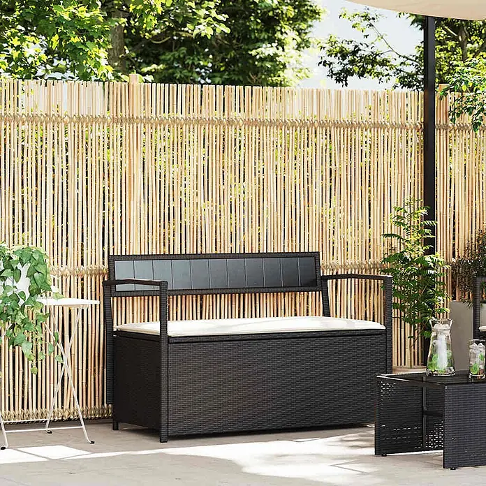 Furnicato Gartenbank PE-Rattan - B x T x H: 111,5 x 54 x 74 cm, Schwarz und Creme - Schwarze Outdoor-Aufbewahrungsbank im Rattan-Stil mit hellem Kissen, bietet Sitzgelegenheit und Stauraum auf einer Terrasse.