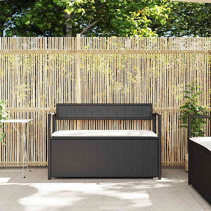 Furnicato Gartenbank PE-Rattan - B x T x H: 111,5 x 54 x 74 cm, Schwarz und Creme - Dunkelbraune Rattan-Gartenbank mit Stauraum und weißem Kissen auf einer Terrasse.