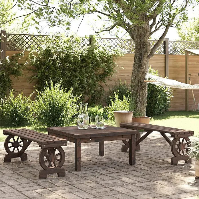 Furnicato Gartenbank Tannen-Massivholz gebrannt - B x T x H: 115 x 28 x 39,5 cm, Dunkelbraun - Dunkle Holz-Gartenmöbelgarnitur mit quadratischem Tisch und zwei Bänken mit dekorativen Wagenrad-Beinen auf einer Ziegelterrasse.