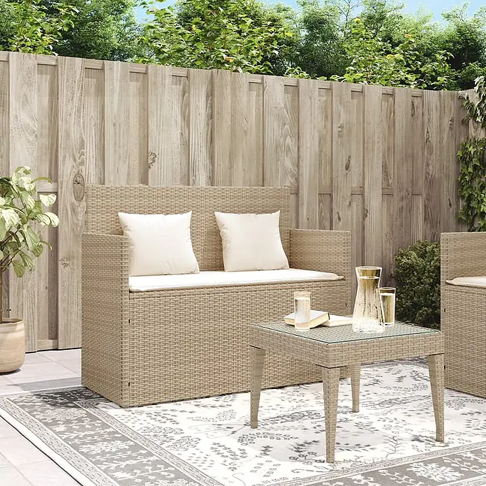Furnicato Gartenbank PE-Rattan - B x T x H: 120 x 50 x 90,5 cm, Beige und Creme - Beige Rattan Garten-Lounge-Set mit weißen Kissen, bestehend aus einem Zweisitzer-Sofa und einem Glastisch auf einer Terrasse.