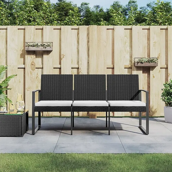 Furnicato Gartenbank PP-Rattan Anthrazit - B x T x H: 152,5 x 57 x 77,5 cm, Schwarz - Schwarzes Rattan-Gartensofa für drei Personen mit weißen Kissen auf einer Terrasse.