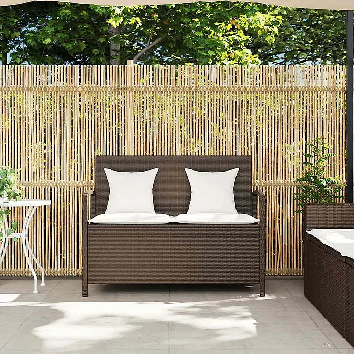 Furnicato Gartenbank PE-Rattan - B x T x H: 111 x 56 x 87 cm, Braun und Creme - Dunkelbraune Rattan-Gartenbank mit Stauraum und weißen Kissen auf einer Terrasse.