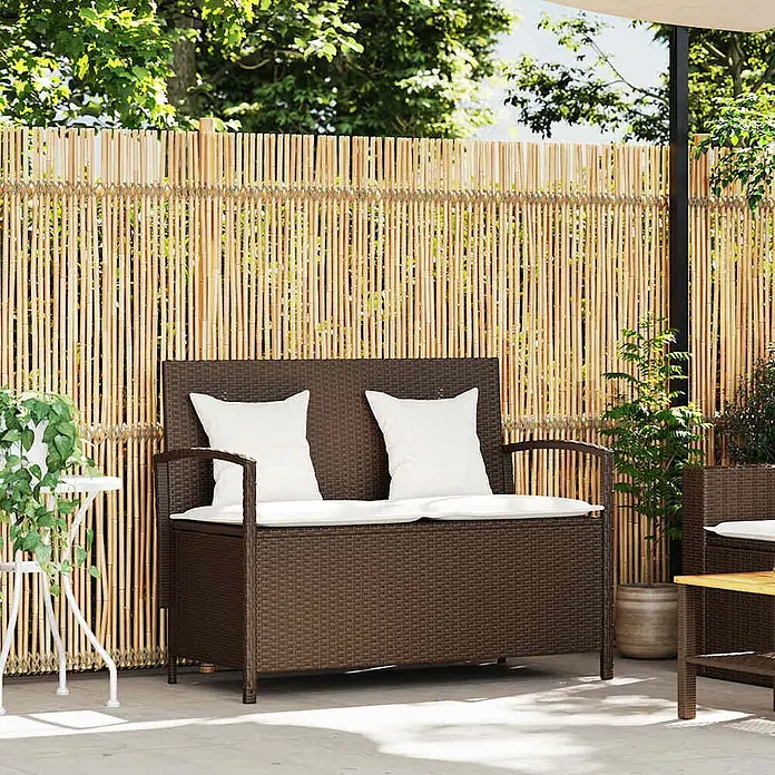 Furnicato Gartenbank PE-Rattan - B x T x H: 111 x 56 x 87 cm, Braun und Creme - Dunkelbraune Rattan-Gartenbank mit Stauraum und weißen Kissen auf einer Terrasse.