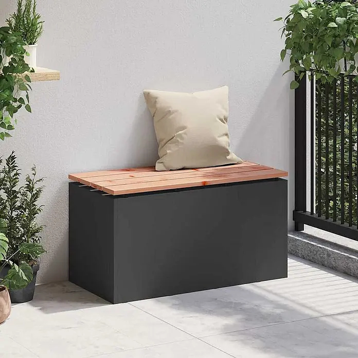 Furnicato Gartenbank - B x T x H: 40 x 40 x 43 cm, Schwarz - Dunkelgraue Garten-Aufbewahrungsbank mit hellbrauner Lattenholzplatte und beigem Kissen, auf einer Terrasse.