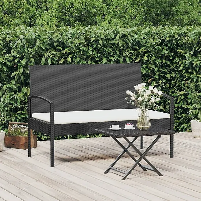 Furnicato Gartenbank - Schwarz und Weiß - Dunkelbraune Rattan-Gartenbank mit weißen Kissen und passendem quadratischem Klapptisch auf einer Holzterrasse.