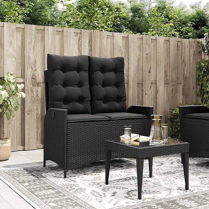 Furnicato Gartenbank - B x T x H: 86 x 86 x 93 cm, Schwarz - Schwarzes Rattan-Outdoor-Sofa (2-Sitzer) mit hohen Rückenkissen und passendem Couchtisch auf einem Terrassenteppich.