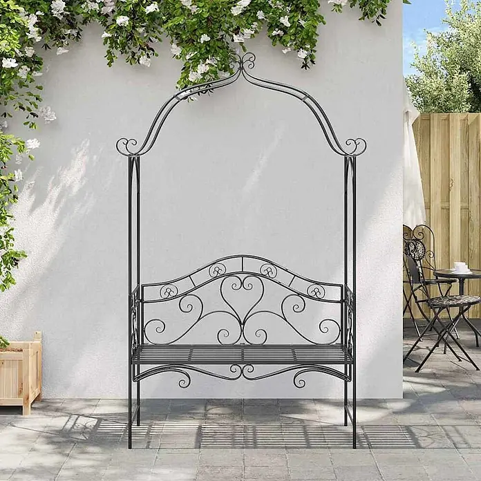 Furnicato Gartenbank Vollstahl - B x T x H: 48 x 121 x 200 cm, Schwarz - Schwarze schmiedeeiserne Gartenbank mit Rankbogen, auf einer Terrasse mit Kletterpflanzen.