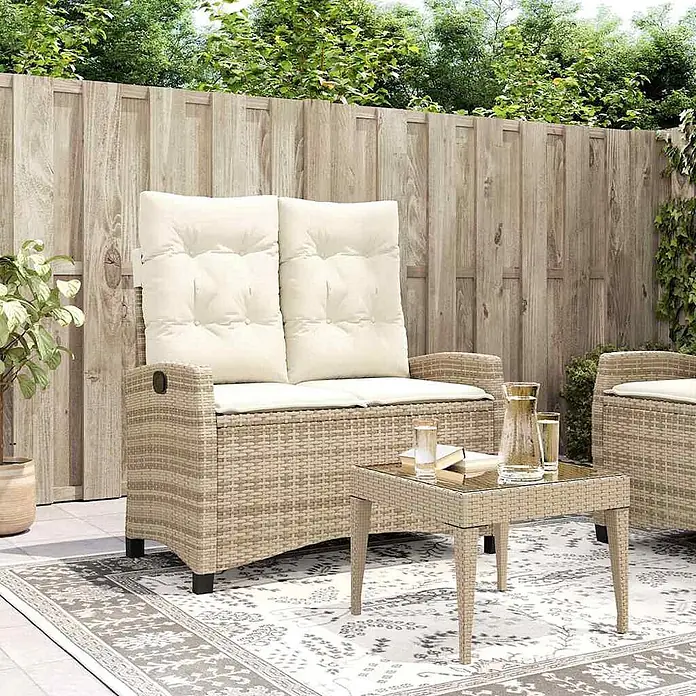 Furnicato Gartenbank PE-Rattan - B x T x H: 105 x 90 x 83 cm, Beige und Creme - Beiges Rattan-Gartensofa für zwei Personen mit cremefarbenen Kissen und passendem Beistelltisch auf einem Terrassenteppich.