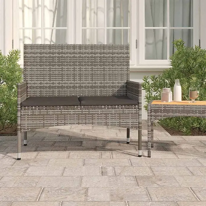 Furnicato Gartenbank PE-Rattan - B x T x H: 90 x 51 x 85 cm, Grau - Graue Rattan-Gartenbank mit dunkelgrauen Kissen und passendem Beistelltisch auf einer Terrasse.