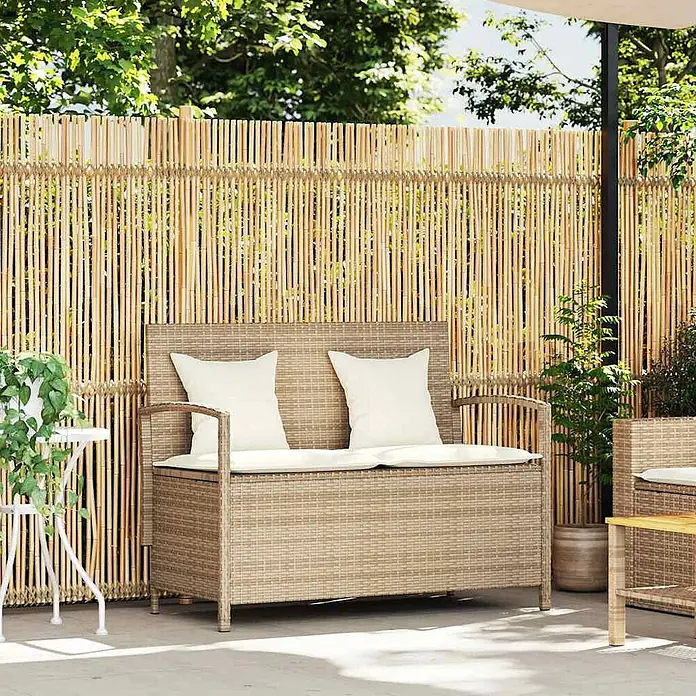 Furnicato Gartenbank - B x T x H: 111 x 56 x 87 cm, Beige und Creme - Braune Rattan-Gartenbank mit Stauraum und weißen Kissen auf einer Terrasse vor einem Bambuszaun.
