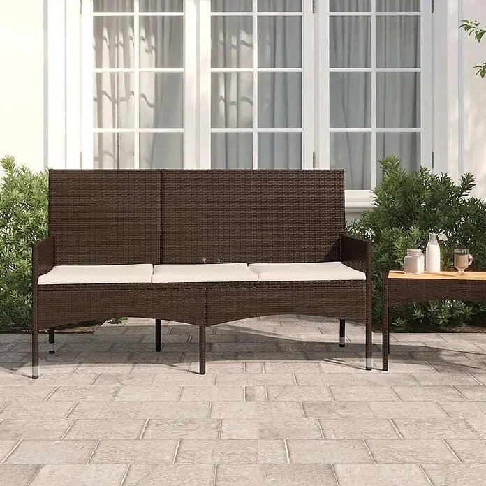 Furnicato Gartenbank - Braun - Dunkelbraune Rattan-Gartenbank mit drei cremefarbenen Kissen auf einer Terrasse.