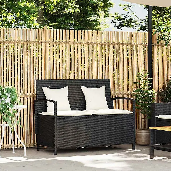 Furnicato Gartenbank PE-Rattan - B x T x H: 111 x 56 x 87 cm, Schwarz und Creme - Schwarze Outdoor-Aufbewahrungsbank aus Polyrattan mit weißen Kissen auf einer Terrasse.