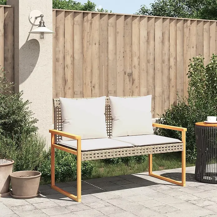 Furnicato Gartenbank PE-Rattan - B x T x H: 119 x 61 x 79 cm, Mischung aus Beige - Zweisitzer-Gartenbank mit hellem Holzrahmen, beigefarbenem Geflechtsitz und weißen Kissen auf einer gepflasterten Terrasse.