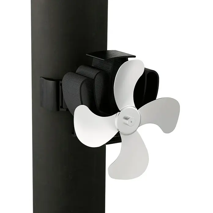 Lienbacher Ofenventilator - Stromlos, Schwarz/Weiß, 50 °C - 345 °C - Nahaufnahme eines Kaminofens mit einem silbernen Ventilator, der die Wärme effizient im Raum verteilt und für eine angenehme Atmosphäre sorgt.